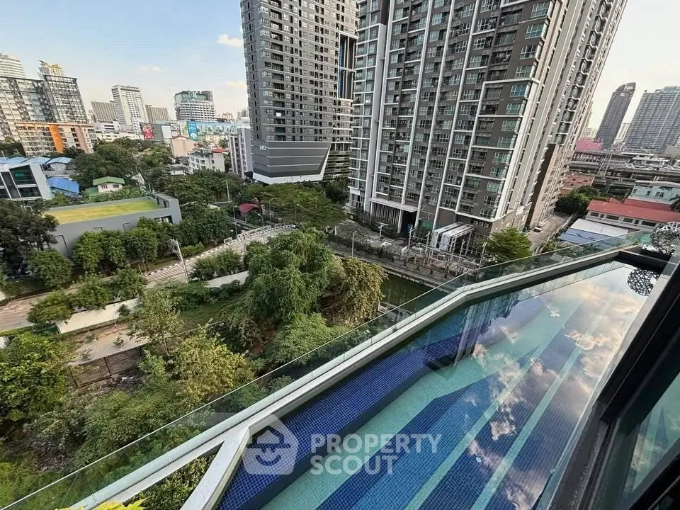 Stunning cityscape view from high-rise balcony with lush greenery and modern architecture.