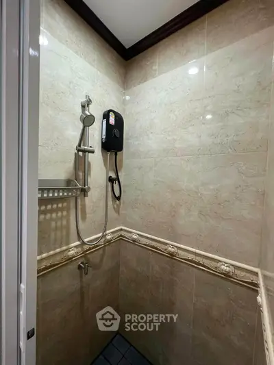 Compact bathroom shower area with elegant tile design and modern fixtures.