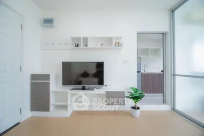 Modern living room with sleek TV setup and open kitchen view, perfect for contemporary living.