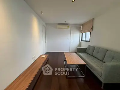 Modern living room with sleek wooden flooring and minimalist furniture