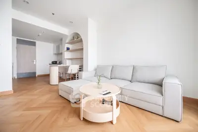 Spacious modern living room with light wood flooring and cozy sectional sofa.