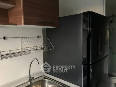 Modern kitchen with sleek black fridge and stainless steel sink