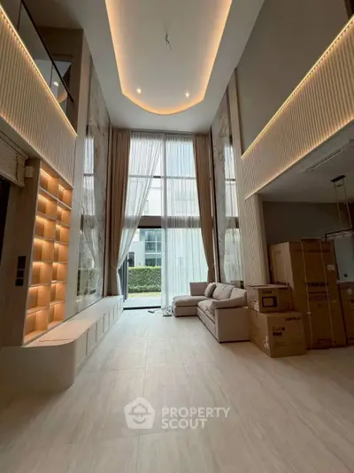 Luxurious high-ceiling living room with modern design and large windows