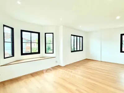 Spacious bright living room with large windows and wooden flooring