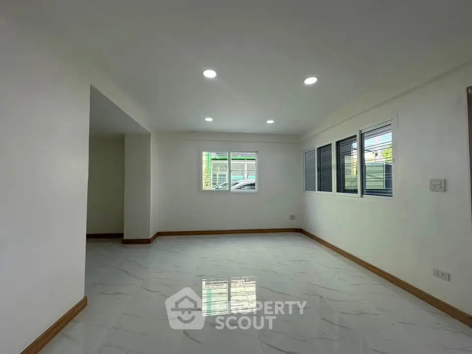 Spacious and bright living room with modern lighting and large windows.