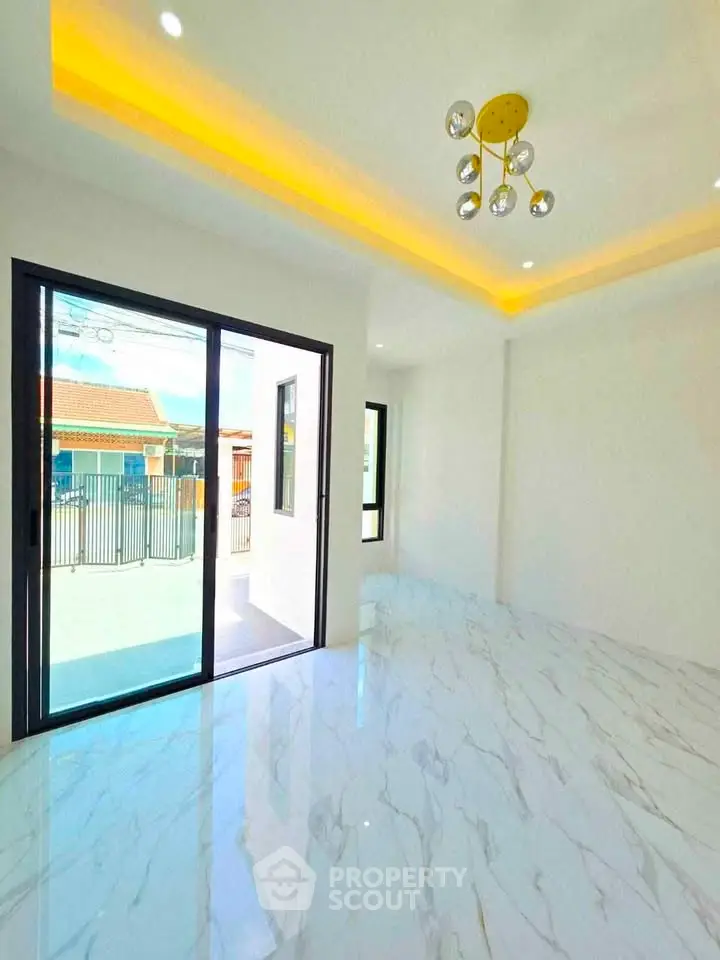 Modern living room with marble flooring and sliding glass doors leading to a balcony.