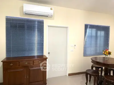Charming interior with air conditioning, wooden furniture, and blue blinds in a cozy living space.