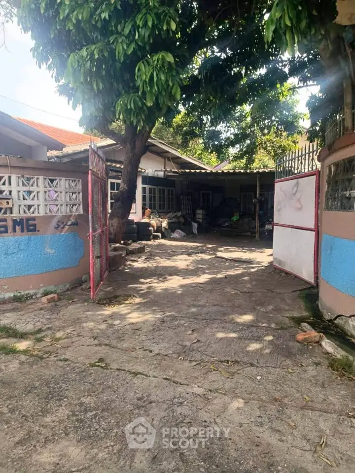 Charming residential property with open gate and lush greenery