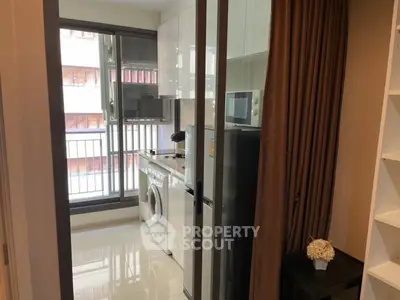 Modern kitchen with washing machine and microwave in sleek apartment