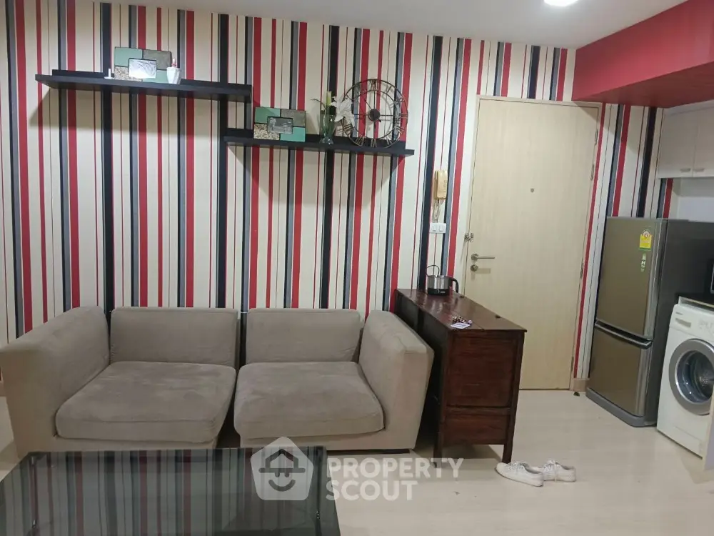 Modern living room with striped wallpaper, cozy sofa, and washing machine