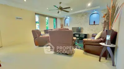 Spacious living room with modern decor and ceiling fan, perfect for relaxation.