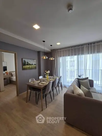 Modern living room with dining area and large windows in a stylish apartment.