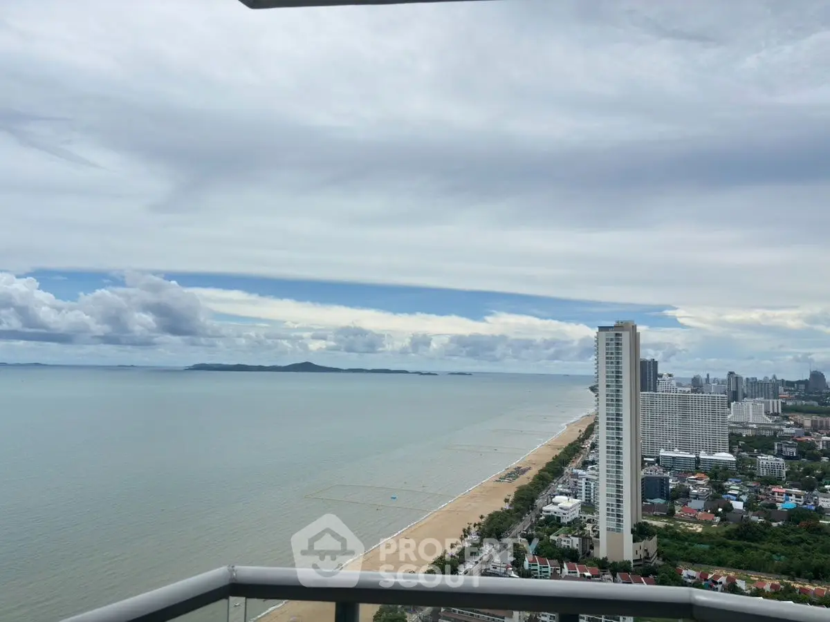 Stunning beachfront view from high-rise balcony overlooking city skyline and ocean.