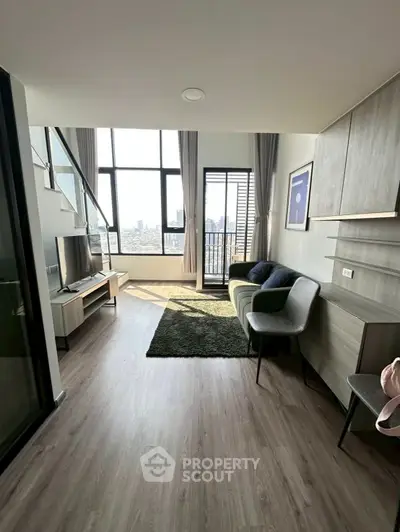 Modern living room with high ceilings and city view, featuring stylish furniture and large windows.