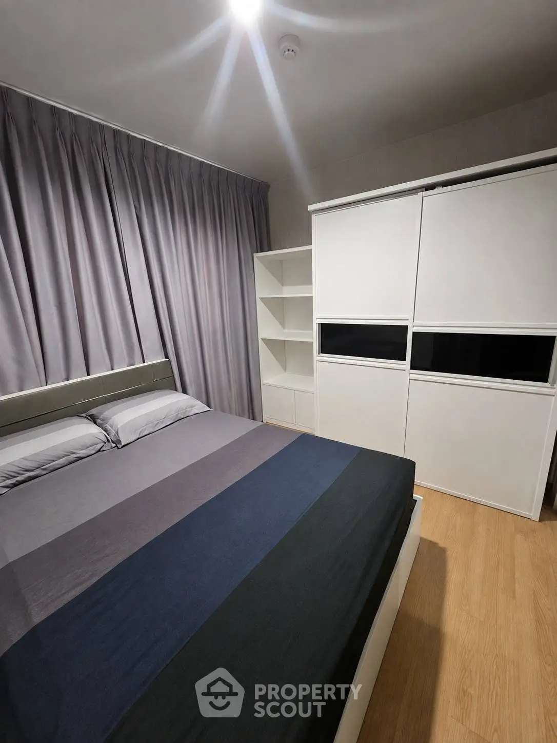 Modern bedroom with sleek design, featuring a comfortable bed and ample storage space.