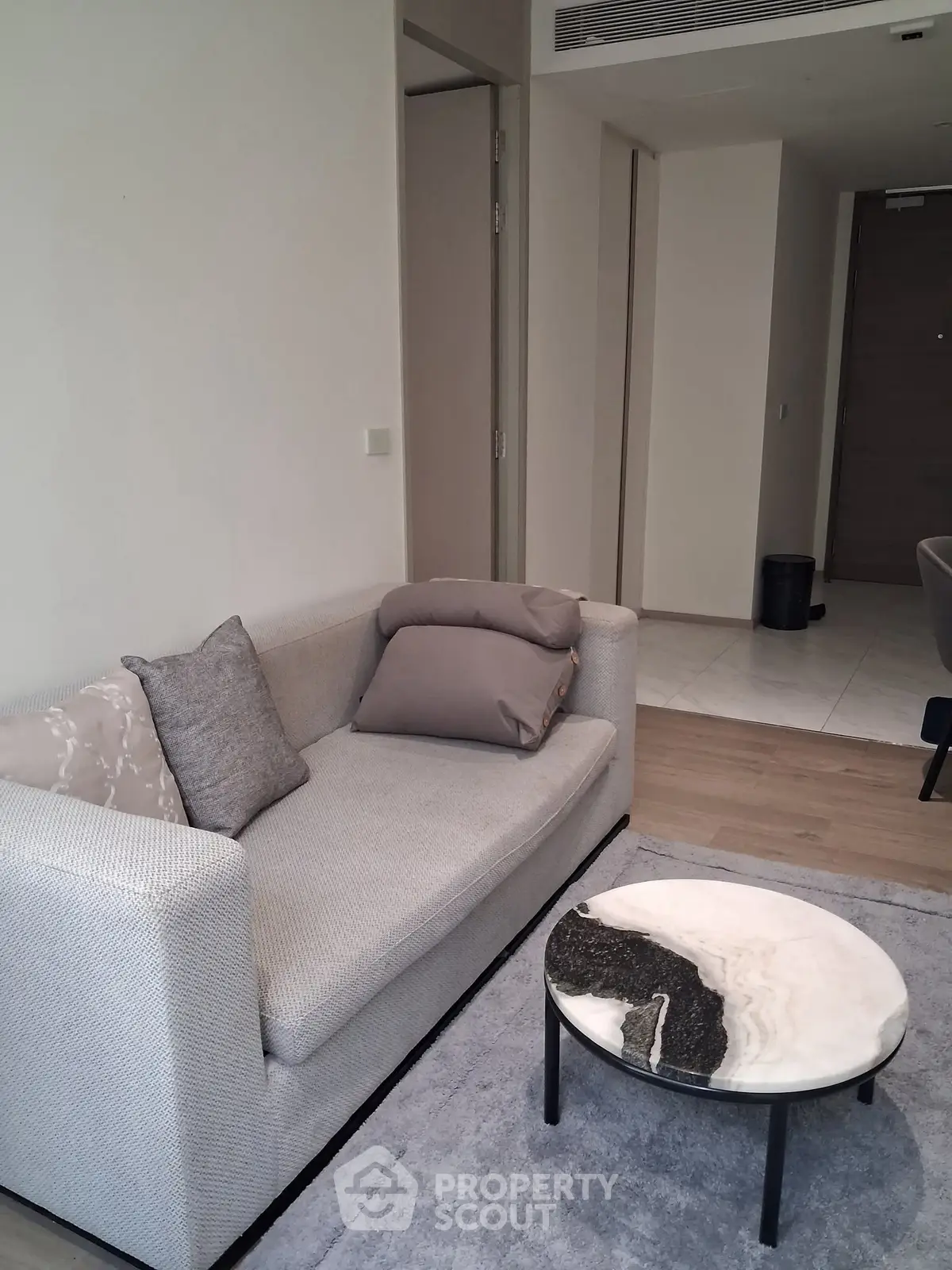 Modern living room with stylish sofa and marble coffee table in a cozy apartment.