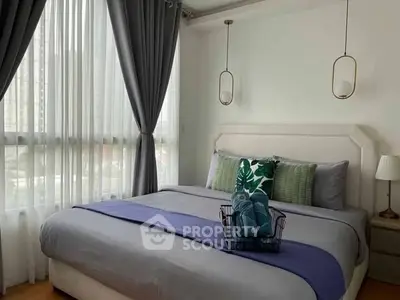 Cozy bedroom with elegant decor and large window offering natural light.