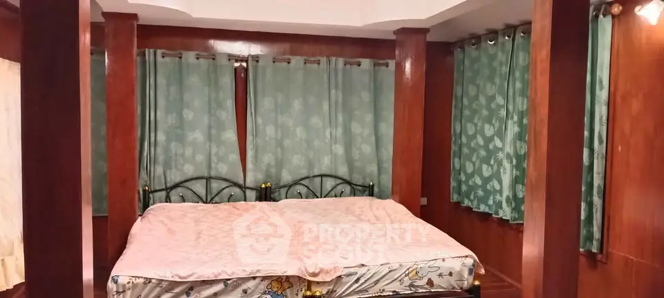 Spacious bedroom with elegant wooden paneling and large windows for natural light.