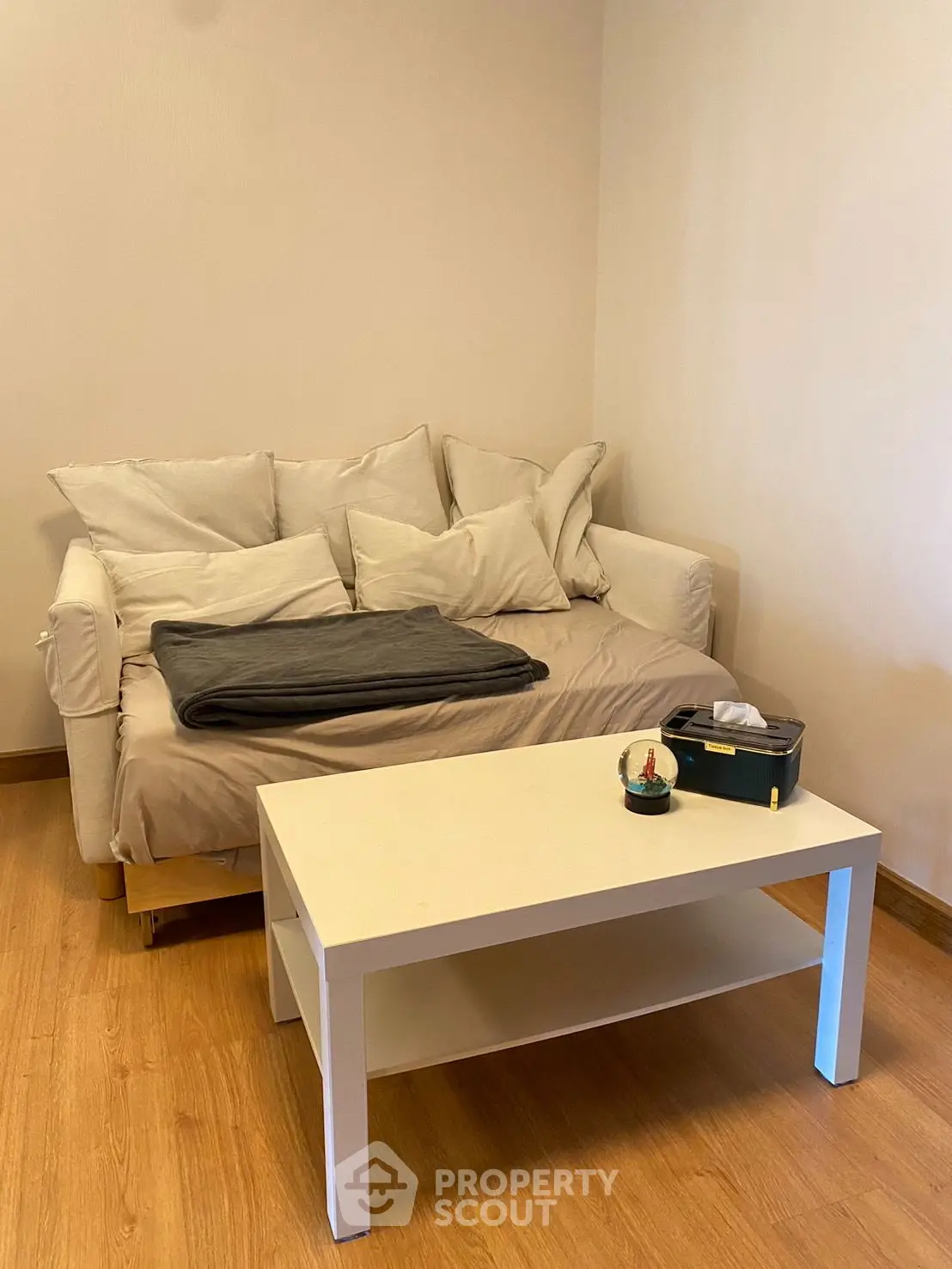 Cozy living room with a comfortable sofa and modern coffee table on wooden flooring.