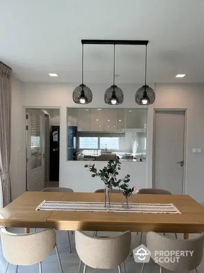 Modern dining area with stylish lighting and open kitchen layout