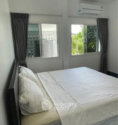 Cozy bedroom with natural light and air conditioning in modern home.