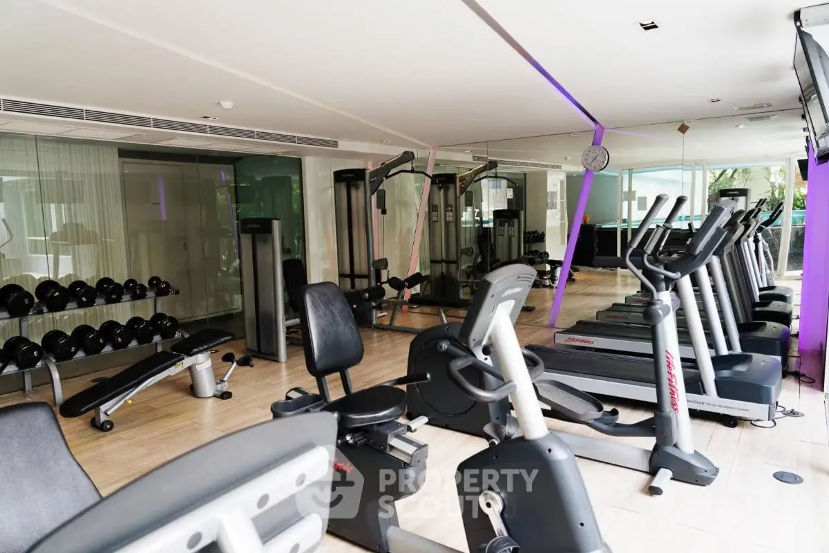 Modern gym with state-of-the-art fitness equipment and mirrored walls in luxury real estate property.