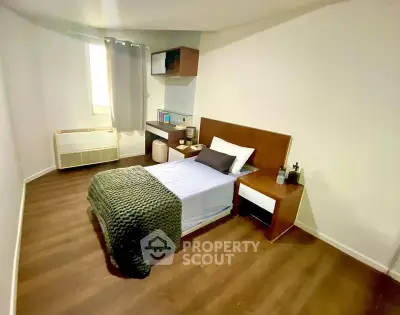 Cozy bedroom with modern furnishings and natural light, perfect for relaxation and comfort.