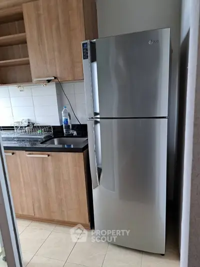 Modern kitchen with sleek stainless steel fridge and wooden cabinets