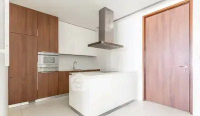 Modern kitchen with sleek cabinetry and built-in appliances in a contemporary apartment.