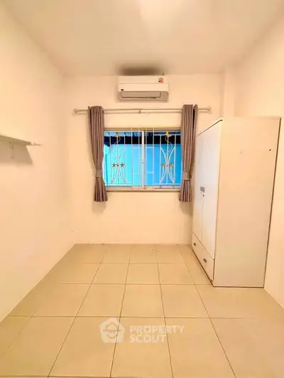 Spacious empty room with air conditioning and wardrobe, ready for customization.