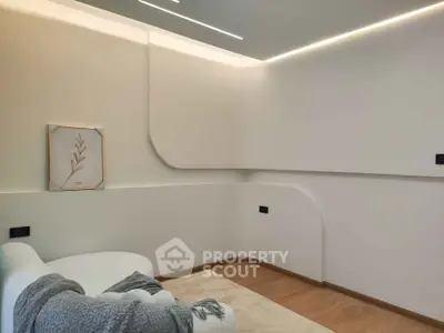 Modern minimalist living room with unique wall design and cozy seating area.