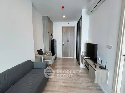 Modern living room with sleek furniture and open layout, featuring a cozy sofa and wall-mounted TV.