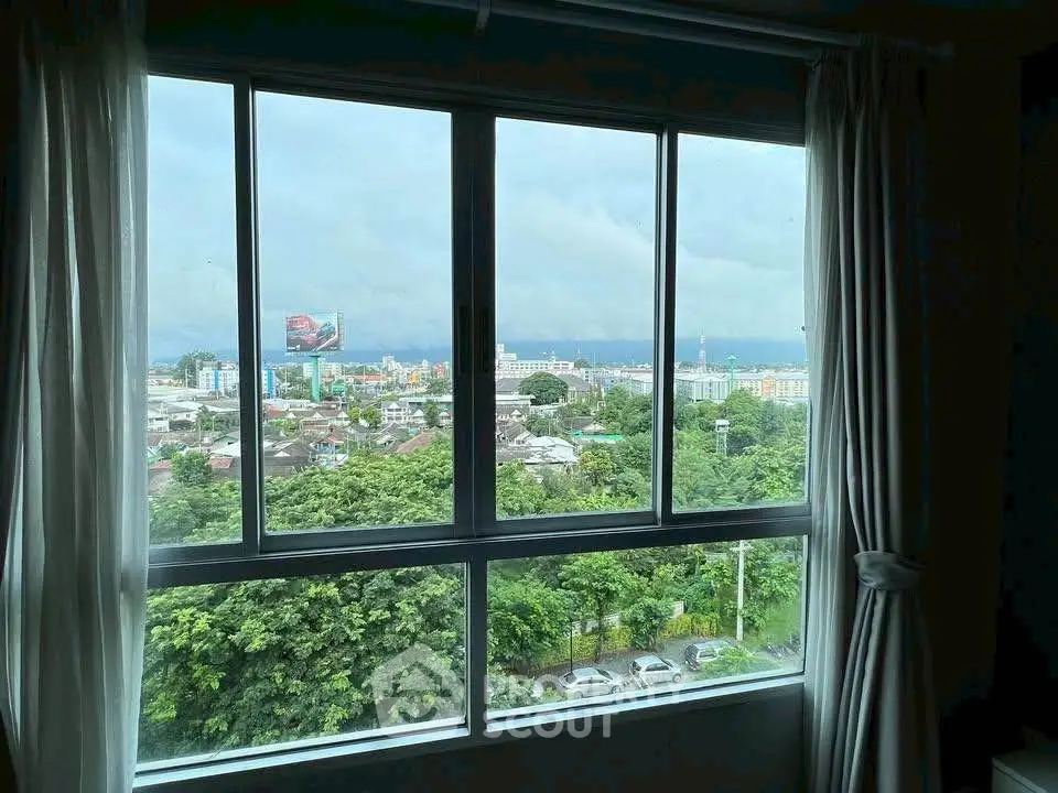 Stunning cityscape view from a modern apartment window with lush greenery and urban skyline.