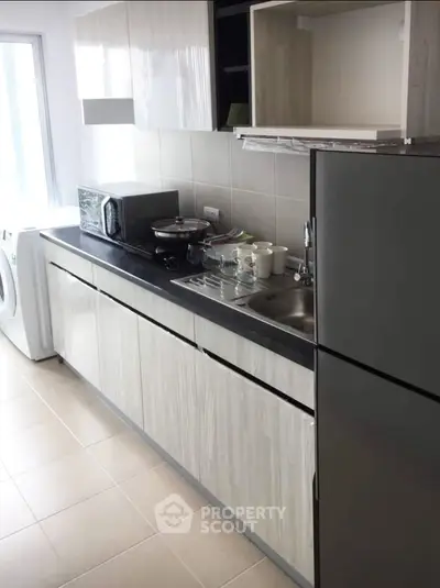 Modern kitchen with sleek cabinetry, stainless steel appliances, and ample counter space in a bright setting.