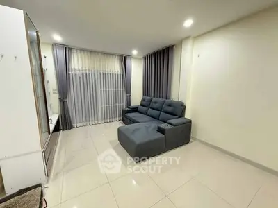 Spacious living room with modern sofa and elegant curtains