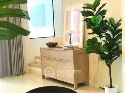 Stylish modern interior with wooden sideboard and lush green plants