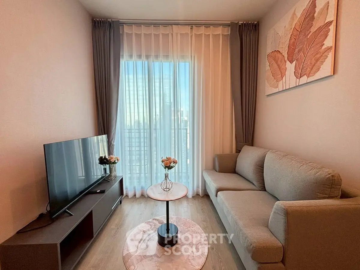 Modern living room with cozy sofa, flat-screen TV, and city view through large window.