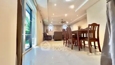 Spacious living room with elegant dining area and large windows for natural light.