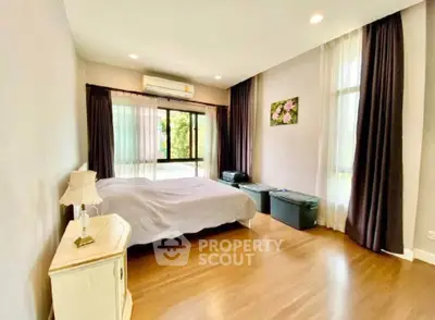 Spacious bedroom with large windows and elegant decor in modern home