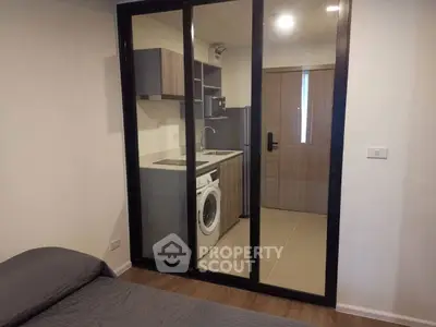 Modern studio apartment with compact kitchen and washing machine