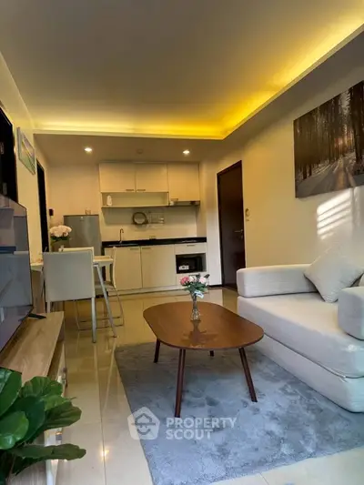 Modern living room with open kitchen, cozy sofa, and elegant decor in a stylish apartment.