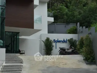 Modern building entrance with sleek design and lush greenery
