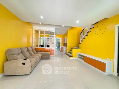 Spacious living room with vibrant yellow walls and modern staircase, perfect for family gatherings.