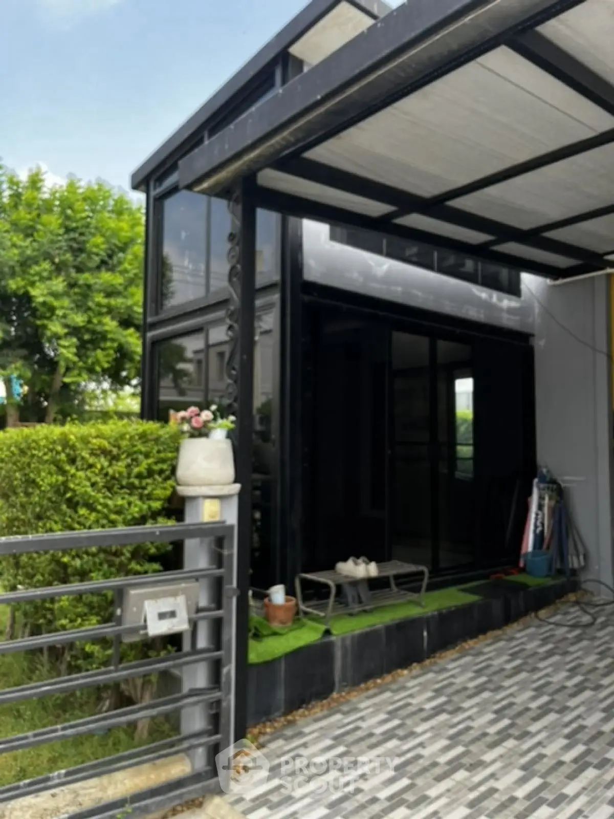 Modern home exterior with sleek black design and lush greenery