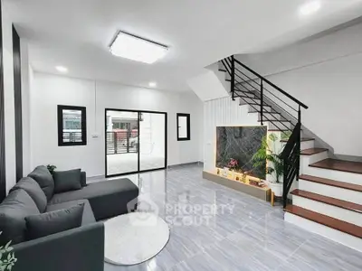 Modern living room with sleek staircase and cozy seating area