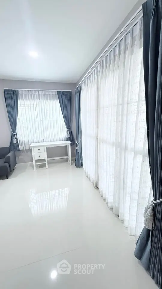 Spacious living room with elegant curtains and natural light