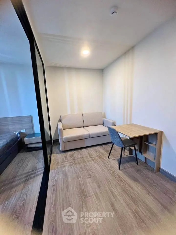 Modern studio apartment with cozy living area and study desk, perfect for urban living.