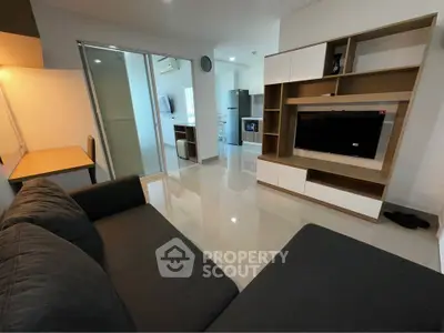 Modern living room with sleek furniture and open kitchen layout in a stylish apartment.