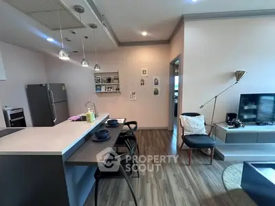 Modern open-layout kitchen and living room with stylish decor and sleek appliances.
