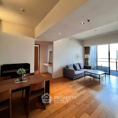 Spacious modern living room with wooden flooring and balcony view